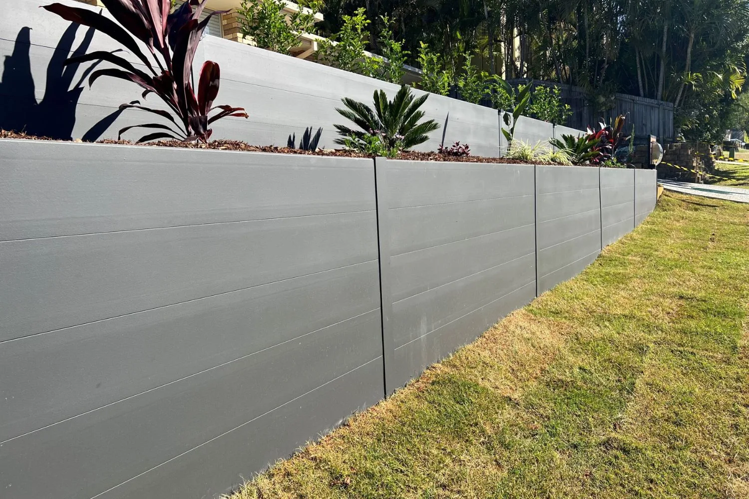 Concrete retaining wall holding back a sloped Northern Beaches yard