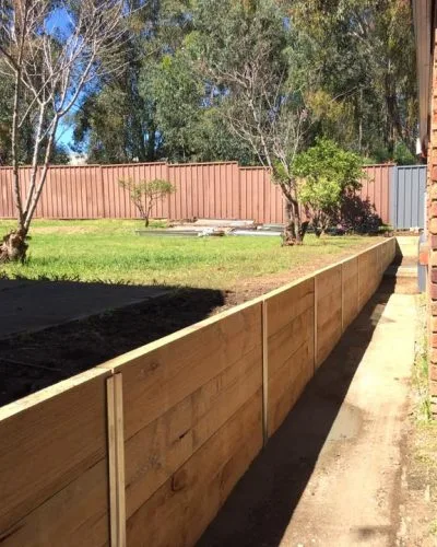 Timber sleeper retaining wall in a landscaped yard