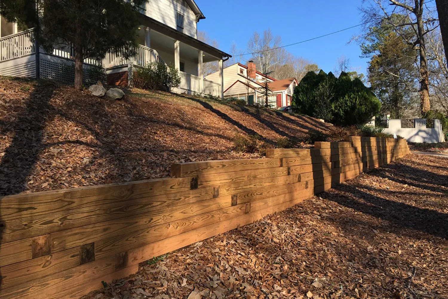 Timber sleeper retaining wall holding back a garden bed