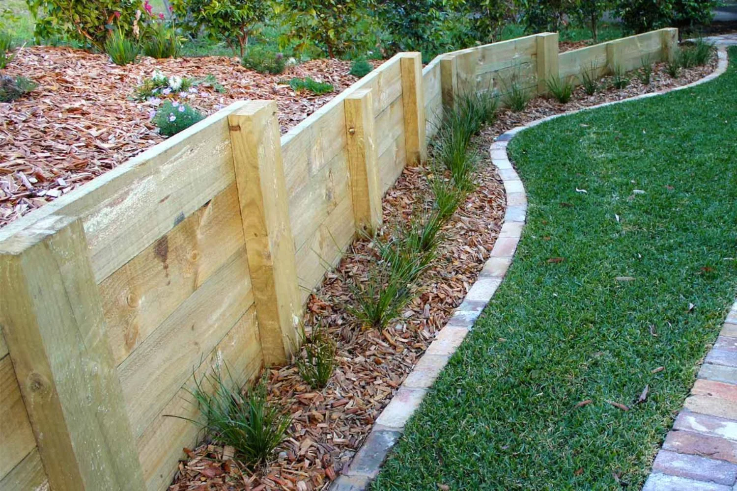 Timber sleeper retaining wall along a boundary line