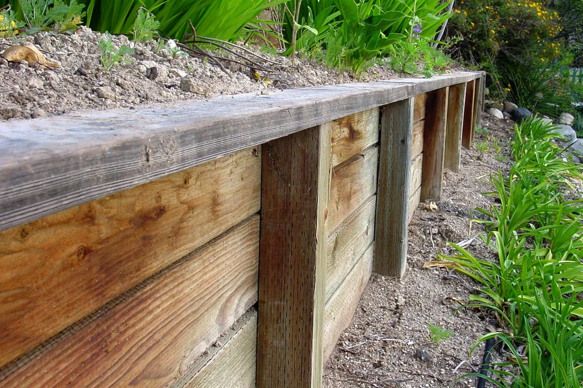 Timber retaining wall holding back a raised lawn