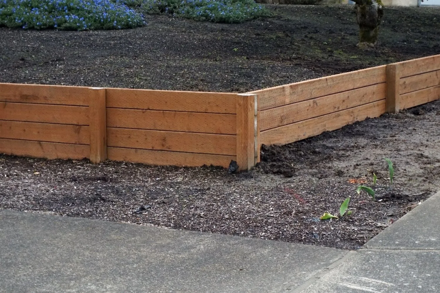 Treated pine retaining wall sleepers set against steel posts